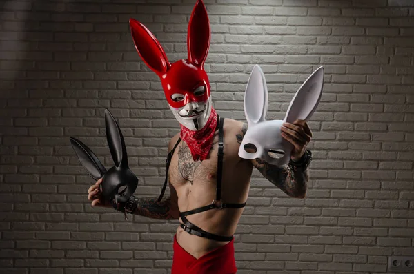Kırmızı tavşan maskeli bir adam tavşan maskesi tutuyor. — Stok fotoğraf