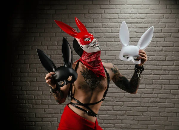 Kırmızı tavşan maskeli bir adam tavşan maskesi tutuyor. — Stok fotoğraf