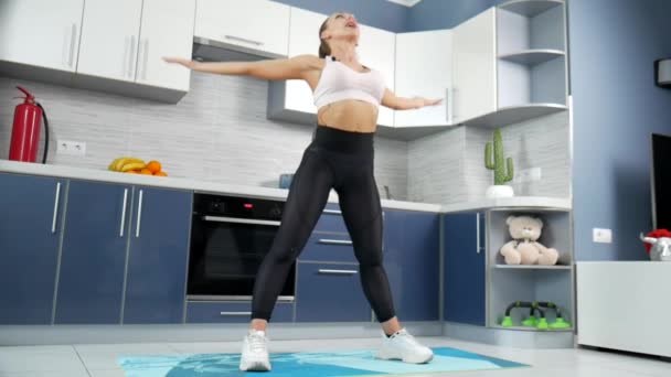 Kadın fitness eğitmeni aboneler için mutfakta online antrenman yapıyor. — Stok video