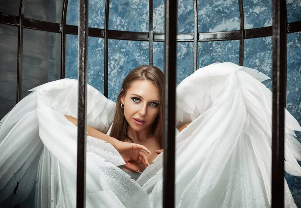 Женщина в клетке с ангельскими крыльями — стоковое фото