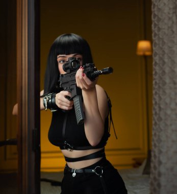 Pencere kenarındaki bir otelde kadın bir tetikçi, cinayet işleyen kurbana teleskopik görüşlü otomatik bir tüfek doğrultuyor.