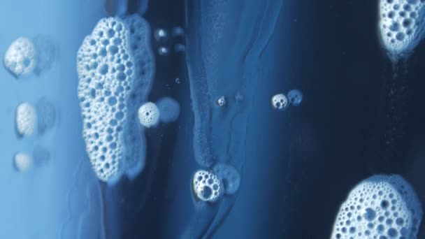 Makroaufnahmen von Seifenblasen, bei denen die Chemie der Fensterputzer schön reflektierend über das Glas fließt — Stockvideo