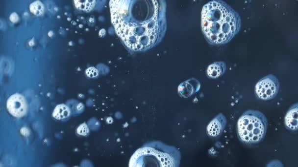 Macrofotografía de burbujas de jabón la química de limpieza de ventanas fluye por el vidrio reflejando maravillosamente — Vídeo de stock