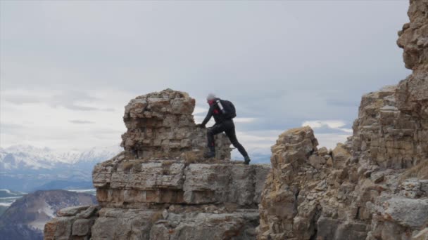Un touriste masculin sur une colline avec vue sur la chaîne de montagnes du Caucase Elbrus se déplace le long du sommet de la crête — Video