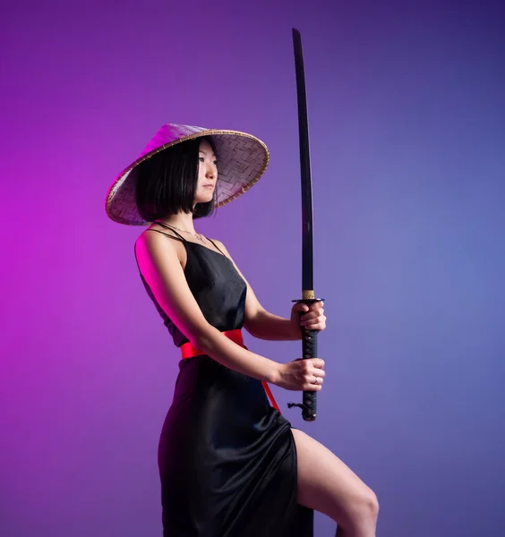 Slender Asian woman an Asian hat with a katana in her hand image of a samurai — Stock Photo, Image