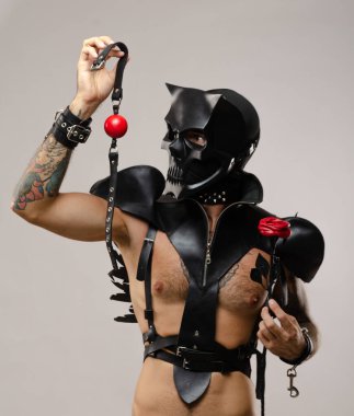 a man in a bdsm mask of a skull demon with a gag, dressed in a leather cloak with leather bracelets and straps on the body clipart