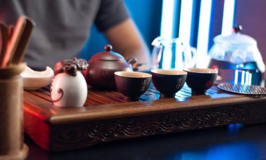 Geleneksel Çin geleneğine göre bir adam çay masasında aletlerle çay yapar.