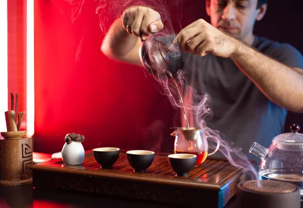한 남자가 전통 중국 전통에 따라 찻잔에서 차를 끓이고 있다 — 스톡 사진