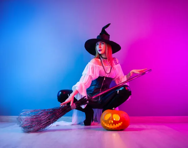 Štíhlá dívka v kostýmu čarodějnice na Halloween s koštětem a dýní — Stock fotografie