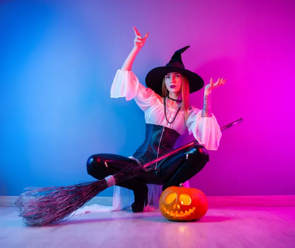 Štíhlá dívka v kostýmu čarodějnice na Halloween s koštětem a dýní — Stock fotografie