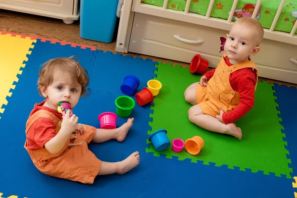 El niño y la niña juegan en un piso de vivero —  Fotos de Stock