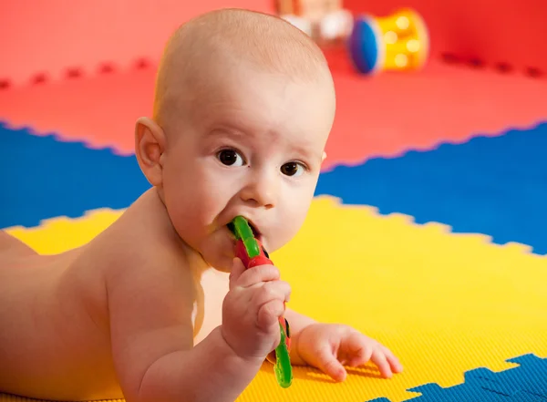 Fechar-se de feliz seis meses bebê menino rastejando em playma colorido — Fotografia de Stock