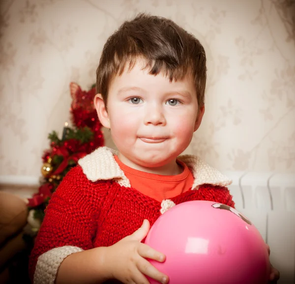 Der Junge sitzt auf einem Pferdespielzeug im Zimmer — Stockfoto