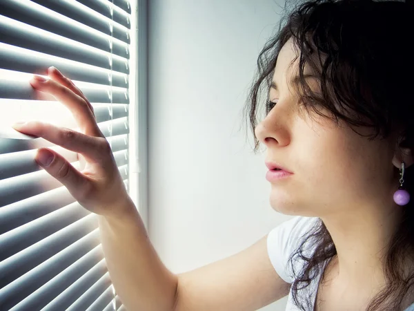 Young female is waiting with hope near window — Stock Photo, Image