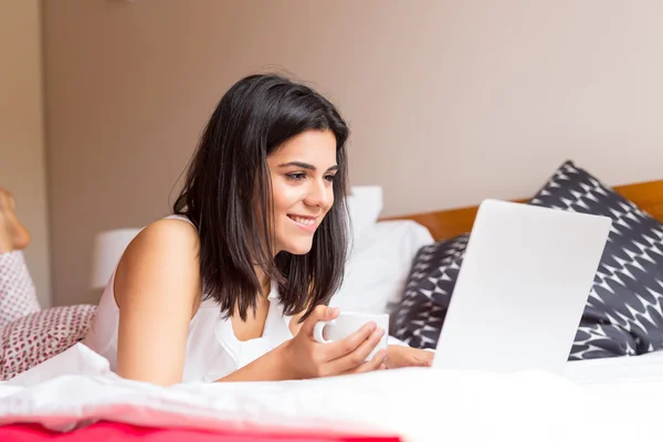 Mulher relaxante com seu computador na cama — Fotografia de Stock