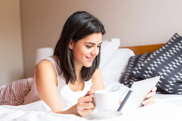 Mulher relaxante com seu tablet digital na cama — Fotografia de Stock