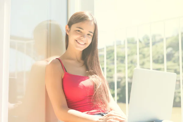 Mujer relajante con un ordenador portátil —  Fotos de Stock