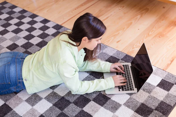 Mujer relajante con un ordenador portátil — Foto de Stock