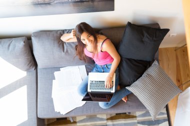 Dizüstü bilgisayar kullanarak ve evde çalışan kadın 