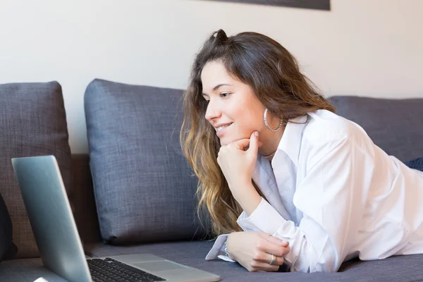 Mujer relajante con un ordenador portátil —  Fotos de Stock