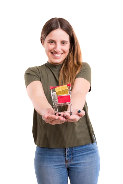 Mulher segurando um carrinho cheio de presentes — Fotografia de Stock