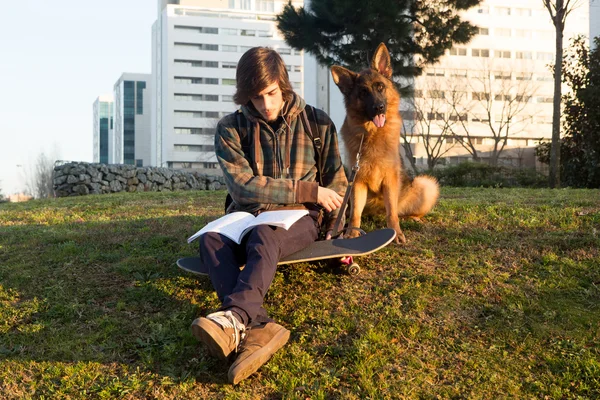 Pojke avkopplande med hund — Stockfoto