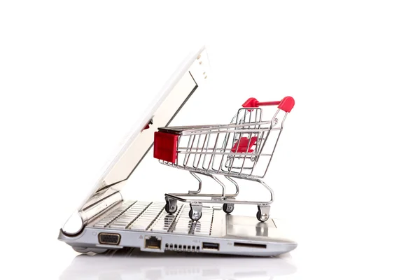 Shopping cart over a laptop — Stock Photo, Image