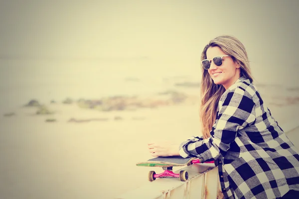 Mooie jonge vrouw met skateboard — Stockfoto