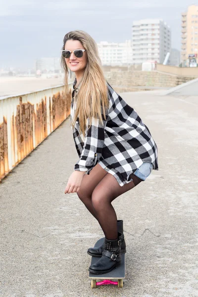 Beautiful young woman with skateboard — Stock Photo, Image