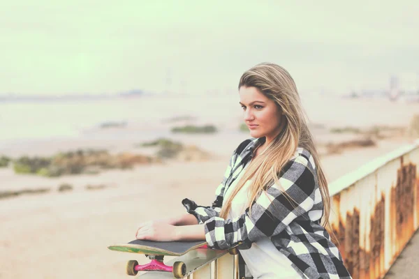 Mulher jovem com skate — Fotografia de Stock