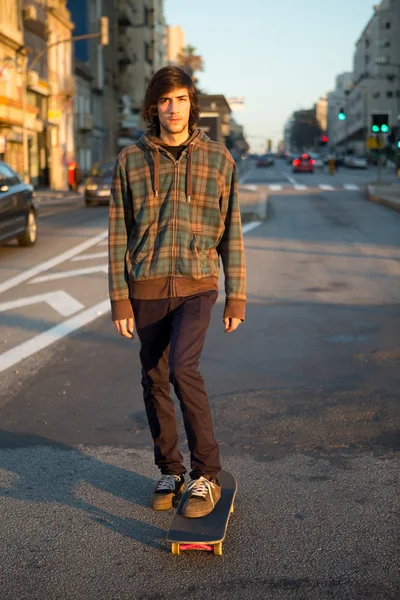 Jovem patinador cruzando a cidade — Fotografia de Stock