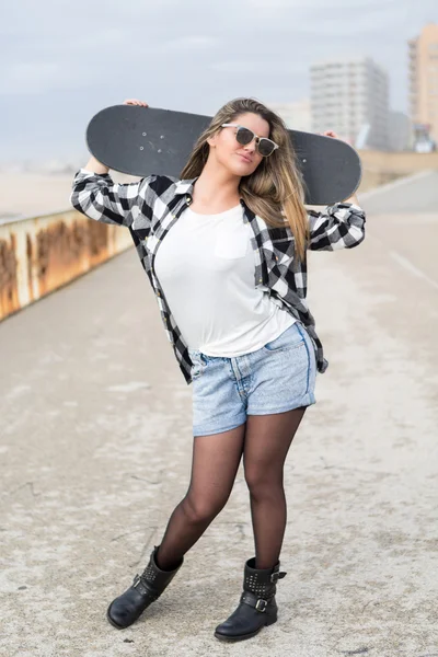 Красивая женщина-скейтбордистка — стоковое фото