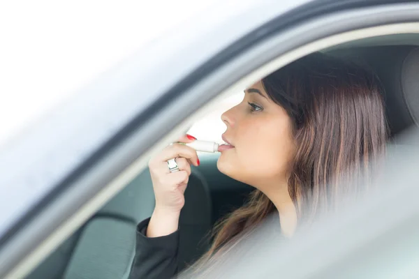 Woman retouching makeup in car — Stock Photo, Image