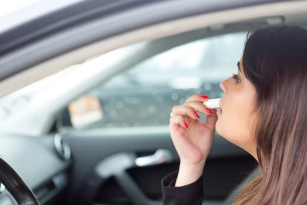 Mujer retocando maquillaje en el coche —  Fotos de Stock