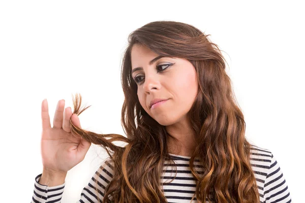 Mujer joven mirando su cabello — Foto de Stock