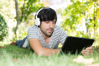 Bahçede tablet kullanan adam