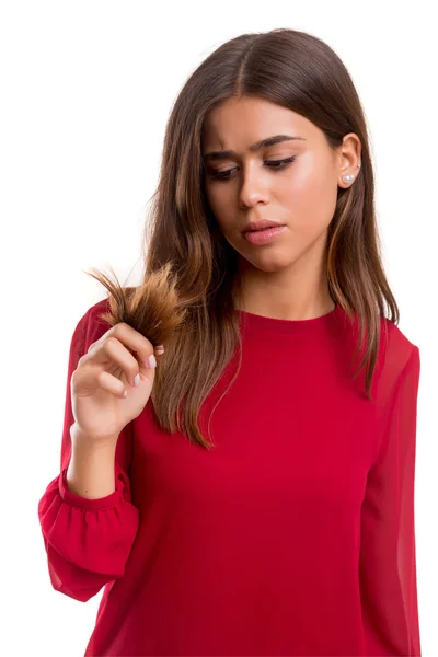 Jovem mulher olhando para o cabelo — Fotografia de Stock