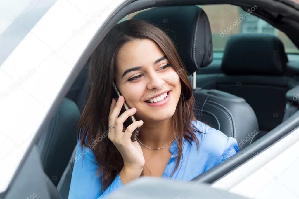 Businesswoman talking on mobile phone in car