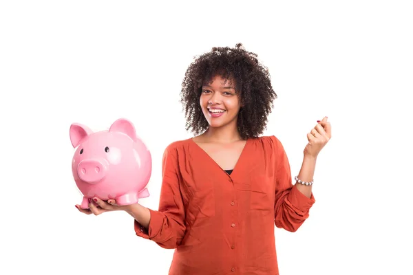 Woman putting some money into a piggy bank — Stock Photo, Image