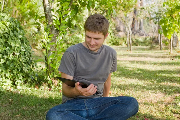 Casual man die werkt met een tablet pc, buiten — Stockfoto