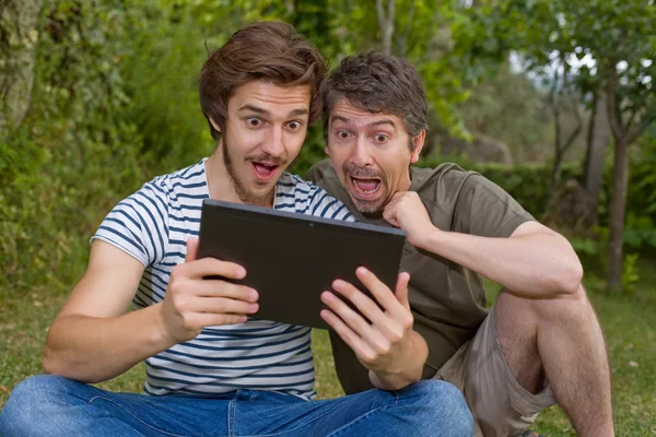 Casual mannen verrast met een tablet pc, buiten — Stockfoto