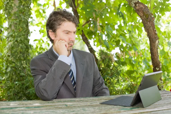 Hombre de negocios preocupado con tableta digital, al aire libre — Foto de Stock