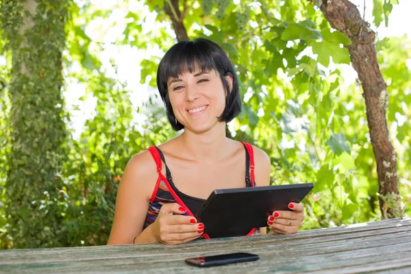 Femme occasionnelle travaillant avec une tablette pc, en plein air — Photo