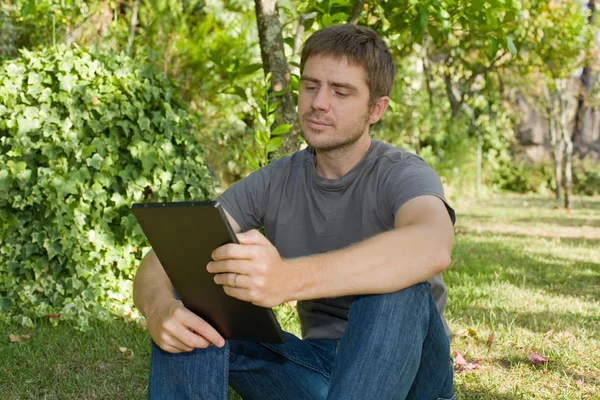 Homem casual trabalhando com um tablet pc, ao ar livre — Fotografia de Stock