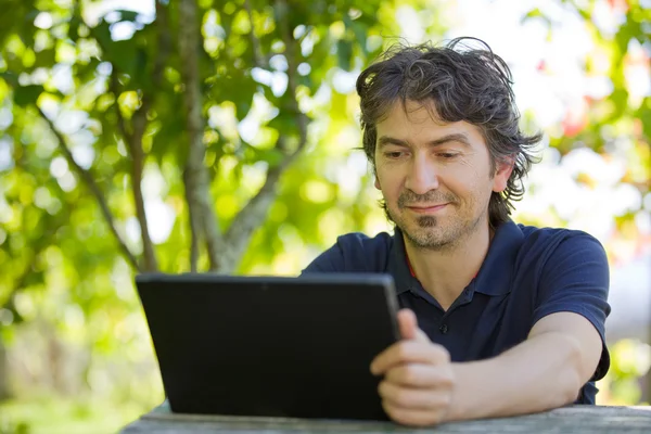 Homem casual trabalhando com um tablet pc, ao ar livre — Fotografia de Stock