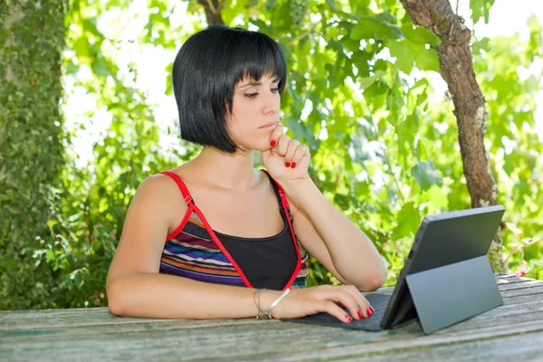 Mujer casual que trabaja con una tableta PC, al aire libre — Foto de Stock