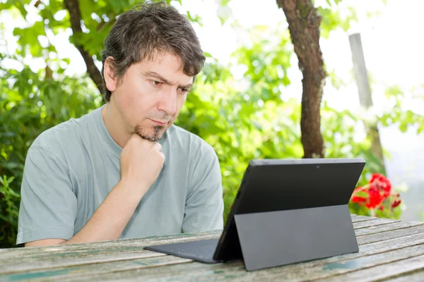 Przypadkowy mężczyzna pracujący z komputerem typu tablet, odkryty — Zdjęcie stockowe