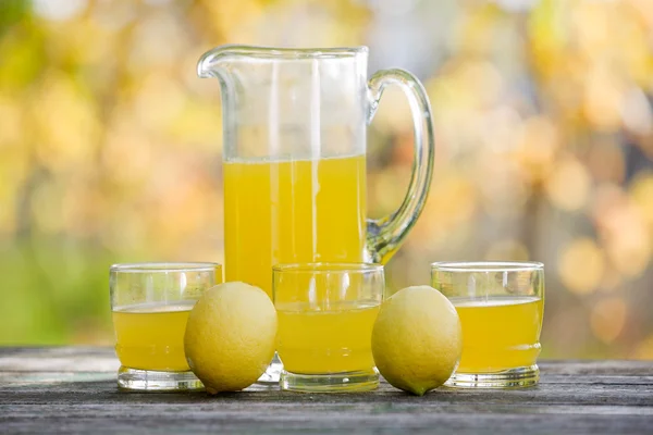 Jus de citron sur une table en bois, set d'automne, extérieur — Photo