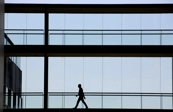 Silhouet weergave van jonge zakenman in een modern kantoorgebouw interieur — Stockfoto