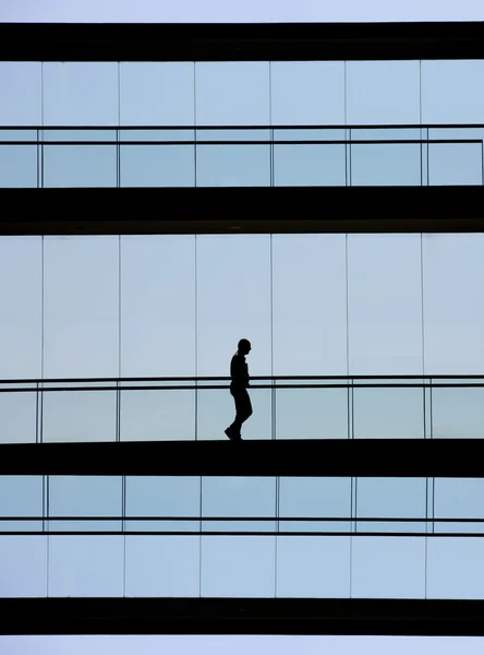 Vista de la silueta del joven empresario en un moderno edificio de oficinas interior —  Fotos de Stock